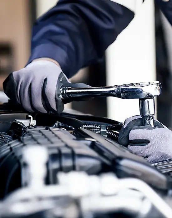 Mechanic Working on a Car Engine at Station Road Garage Close-up of a mechanic using a ratchet spanner while working on a car engine at Station Road Garage - Car servicing in Cambridge