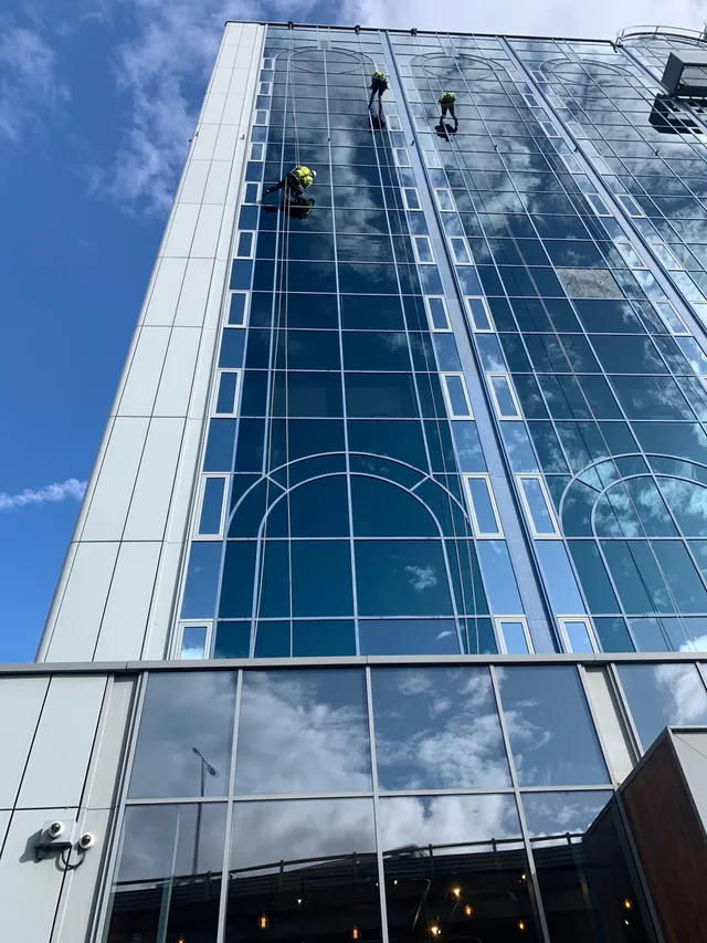 Tall glass building with workmen