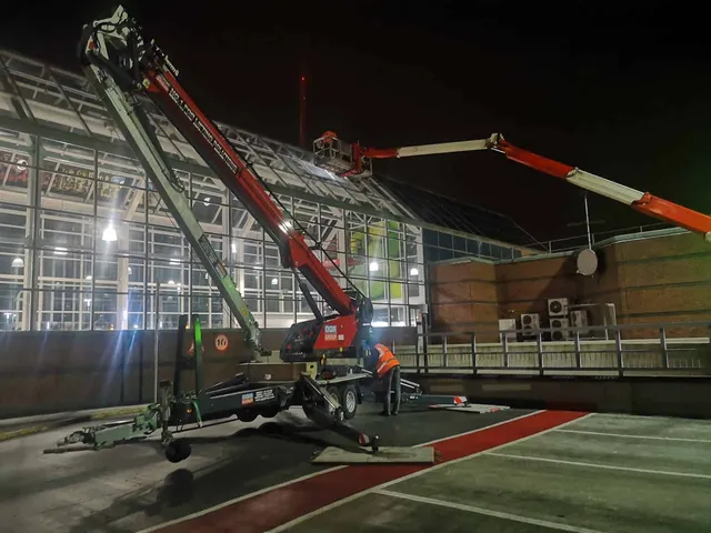 Atrium glass replacement with crane at night