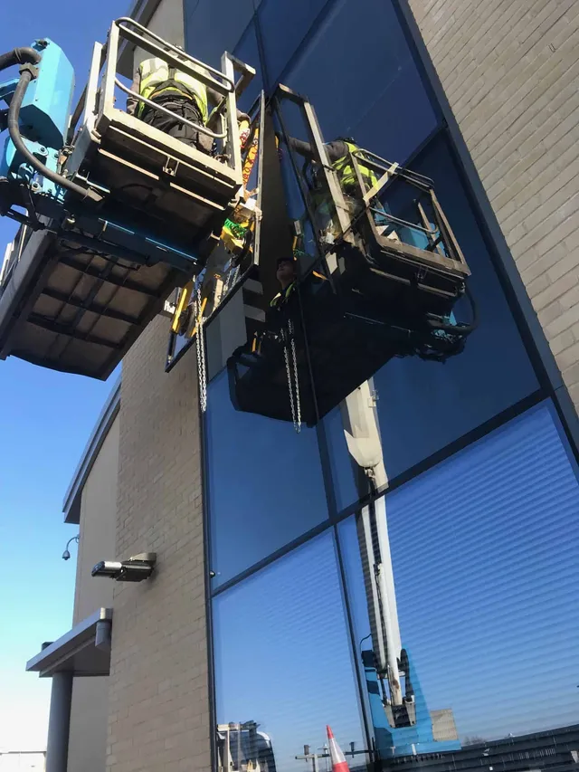 Workmen replacing curtain wall glazing