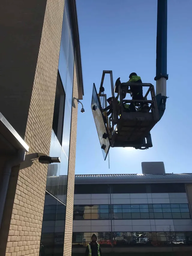Accessing high curtian wall glazing with cherry picker