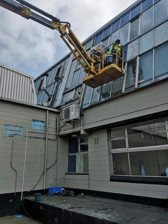 Workmen renewing a glass curtain wall