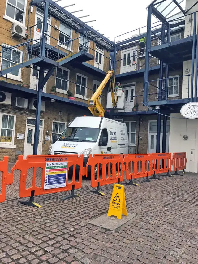 Glass Canopy Repairs at Pepys Court Technicians using a van-mounted access platform to carry out glass canopy repair work in the courtyard at Pepys Court.