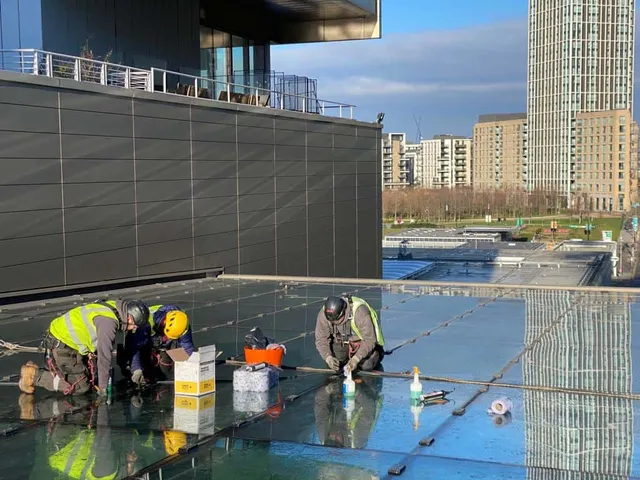 Workmen repairing a glass roof