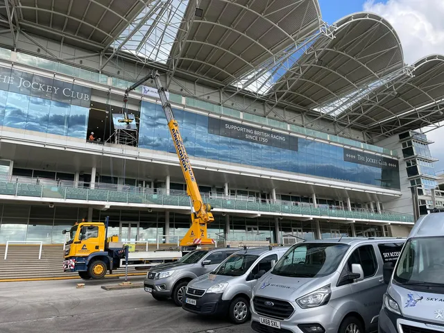 Glazed Canopy Repairs at The Jockey Club Crane and glass lifting equipment being used to carry out glazed canopy repair work at The Jockey Club grandstand.