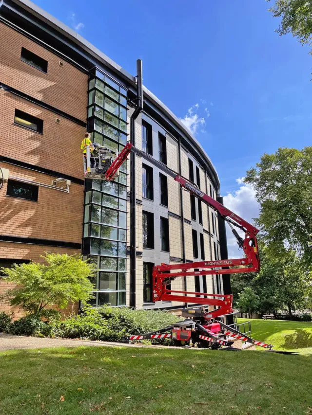 High-Level Glass Maintenance Using Mobile Access Platform Technician using a mobile access platform to carry out high-level glass and façade maintenance on a multi-storey commercial building.