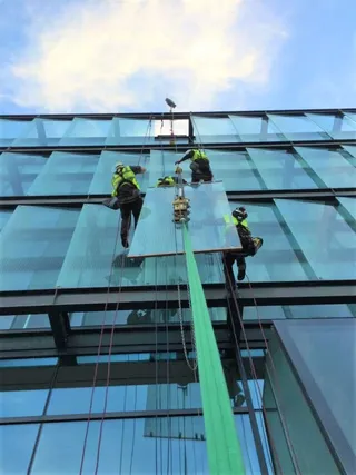 Workmen replacing high-level glazing