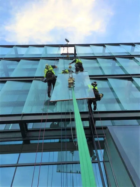 Workmen replacing high-level glazing