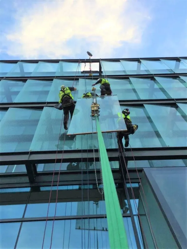 Workmen replacing high-level glazing