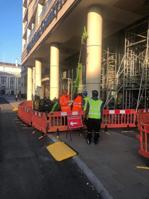Workmen replacing oversized glass