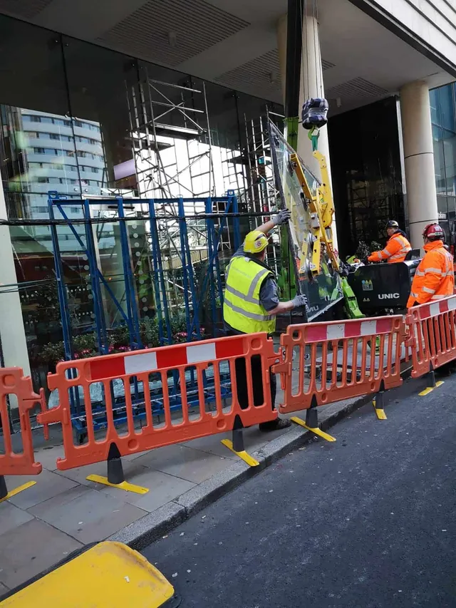 Workmen replacing oversized glass