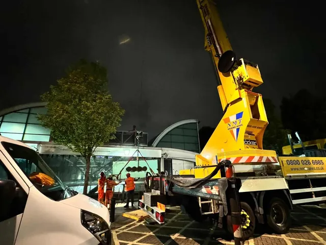 Workmen working at night on railway glazing