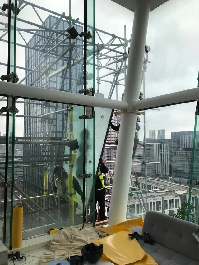 Workmen replacing glazing on high rise building