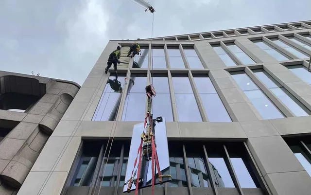 Workmen replacing glass